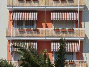 ein hohes Gebäude mit Balkonen mit Pflanzen drauf in der Unterkunft Hotel Ancora Riviera in Lavagna