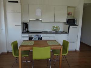 eine Küche mit einem Holztisch und grünen Stühlen in der Unterkunft Villa Sonnenhof in Bad Steben