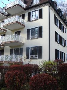 ein weißes Gebäude mit schwarzen Fenstern und Balkonen in der Unterkunft VIP Apartment Baden-Baden in Baden-Baden