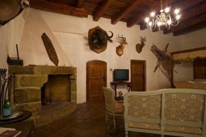 a living room with a stone fireplace and a chandelier at Zamek Zabreh in Ostrava