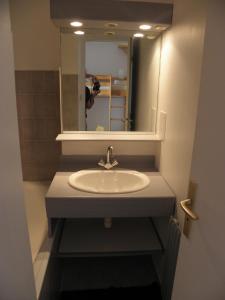 a person taking a picture of a sink in a bathroom at La Dauphinoise Alpe d'Huez in L'Alpe-d'Huez