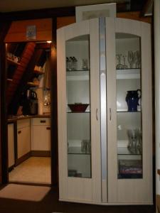 a white cabinet with glass doors in a kitchen at Ferienhaus Sommerland Auszeithütte in Freyung