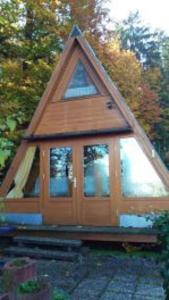 una cabina con tetto triangolare e porta a vetri di Ferienhaus Sommerland Auszeithütte a Freyung
