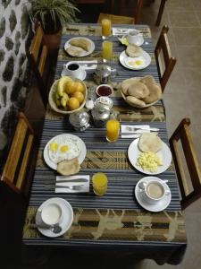 a table with plates of breakfast food on it at B&B Chayana Wasi in Ollantaytambo