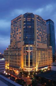 un gran edificio con luces delante en New Coast Hotel Manila (formerly New World Manila Bay Hotel), en Manila