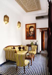 sala de estar con sofá, sillas y mesa en Riad Alya, en Fez