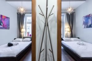 dwa łóżka w pokoju z dwoma lustrami w obiekcie Apartamenty Centrum Częstochowa Stara Kamienica w mieście Częstochowa