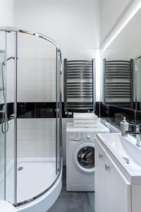 biała łazienka z pralką i umywalką w obiekcie Apartamenty Centrum Częstochowa Stara Kamienica w mieście Częstochowa