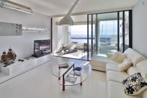 salon z białą kanapą i telewizorem w obiekcie Atico Puerto Banus, Marbella w Marbelli
