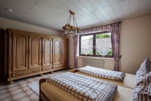 a bedroom with two beds and a window at Ferienwohnung "Am Fuchsgraben" in Tholey