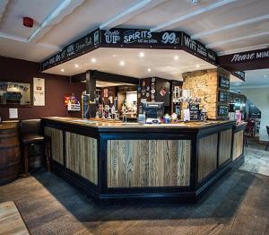 a large wooden bar in a restaurant with a counter at The Dyvels Inn in Corbridge