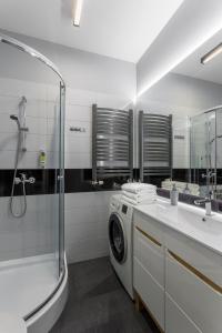 y baño con lavadora y lavamanos. en Apartamenty Centrum Częstochowa Stara Kamienica en Częstochowa