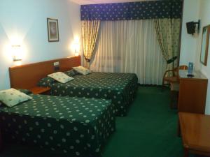 Habitación de hotel con 2 camas y mesa en Hotel Scala, en Padrón