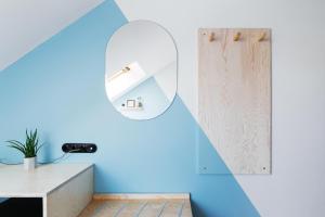 een kamer met een blauwe muur en een spiegel bij Pokrovka 6 Hotel in Moskou