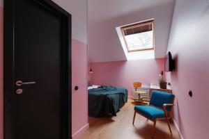 um quarto com uma cama, uma cadeira e uma janela em Pokrovka 6 Hotel em Moscou