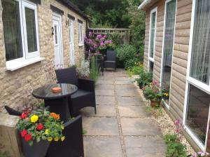 a patio with a table and chairs and flowers at The old post office in Bicester