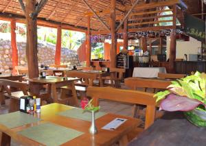 マヌエル・アントニオにあるTabulia Treeの木製のテーブルと椅子、カウンターが備わる空きレストランです。