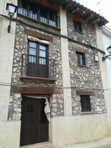 a stone building with a door and a balcony at Casa Francisco Teruel in Cascante del Río