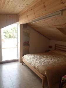 1 dormitorio con cama y ventana grande en Villa Anna, en Agnone Bagni