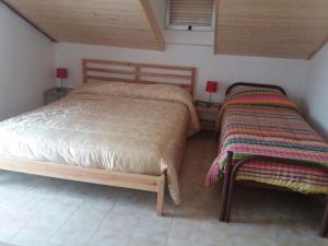 1 dormitorio con 2 camas y 2 mesas con lámparas en Villa Anna, en Agnone Bagni