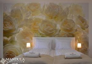 a bedroom with a mural of roses on the wall at Mandula Apartman in Cegléd