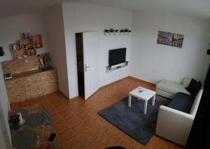 a living room with a couch and a tv at Apartman Lena in Osijek