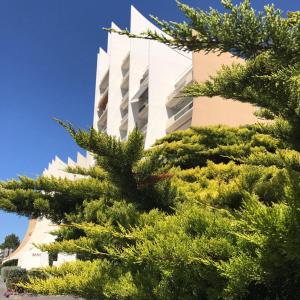 un bâtiment avec des arbres devant lui dans l'établissement Vue Mer Santa Clara 3, à La Baule