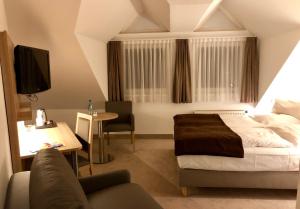 a bedroom with a bed and a desk and a couch at Hotel Wetzlarer Hof in Wetzlar