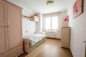 una piccola camera da letto con un letto e una finestra di Casa Rural La Guea de Teruel a Teruel