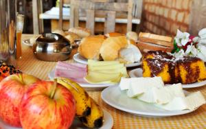 a table topped with plates of food with apples and cheese at Salto Corumbá Hotel Camping Clube in Corumbá de Goiás