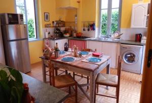 uma cozinha com uma mesa com cadeiras e um frigorífico em The Railway Cottage at Montazels em Espéraza