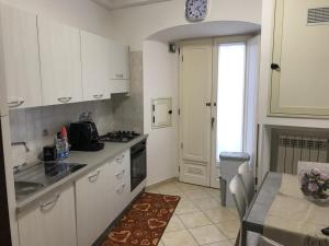 カタンザーロにあるHouse Corso Mazzini 214の白いキャビネットと壁掛け時計付きのキッチン