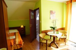 a room with green walls and a table and chairs at Willa Grażyna in Ustroń