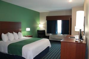 una camera d'albergo con un grande letto e una scrivania di Brookstone Lodge & Suites - Emmetsburg a Emmetsburg