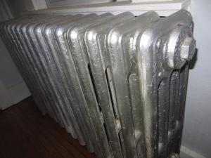 a silver radiator sitting on the floor next to a wall at Historic LaSalle Downtown in Fort Wayne