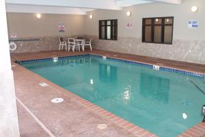 una grande piscina con tavolo e sedie di Brookstone Lodge & Suites - Emmetsburg a Emmetsburg