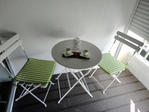 a small table with two chairs and a tea set on it at Tarik Moments Apartment in Portimão