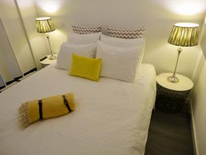 una camera da letto con un letto bianco con due lampade di Tarik Moments Apartment a Portimão