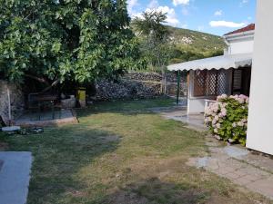 a yard with a tree and a building at Apartments Polic with Terrace in Baška