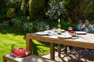 a picnic table with a bottle of wine and glasses at Gwithian Holidays in Hayle