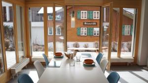 a dining room with a table and chairs and windows at Chalet Bella Vista 1 in Wengen