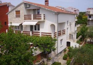 una casa blanca en una colina con árboles en Apartments Mima, en Zadar