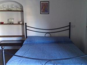 Pieve di Santa LuceにあるPalazzo Residence Giuli Rosselminiのベッドルーム1室(青いベッドカバー付)
