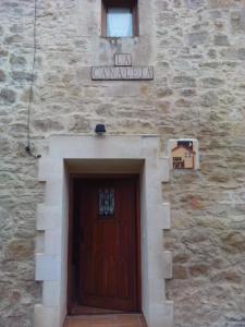 un edificio con una puerta de madera y una señal sobre él en La Canaleja, en Cigüenza