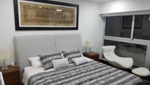 a bedroom with a bed and a chair and a window at Exclusive Apartment in Lima