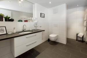 a white bathroom with a sink and a toilet at Louisa in Oberstdorf