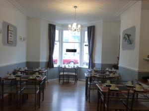 a dining room with tables and chairs and a large window at Hornby House Hotel in Blackpool
