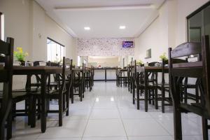 a dining room with wooden tables and chairs at O Neves Hotel in Guanambi