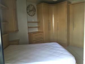 Un dormitorio con una cama y un reloj en la pared. en LINDO APARTAMENTO EM MEIA PRAIA-1 quadra do mar! Melhor localização!, en Itapema