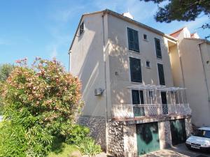 un edificio blanco con un árbol delante en Apartment Sandra, en Dubrovnik